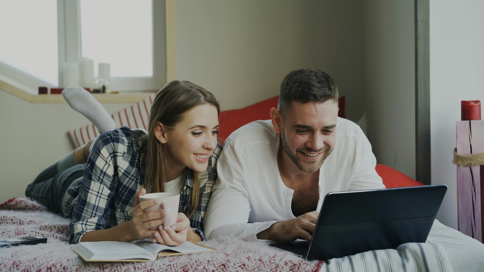 Younger couple browsing on a laptop at home (photo: Vitaly Gariev / Unsplash)