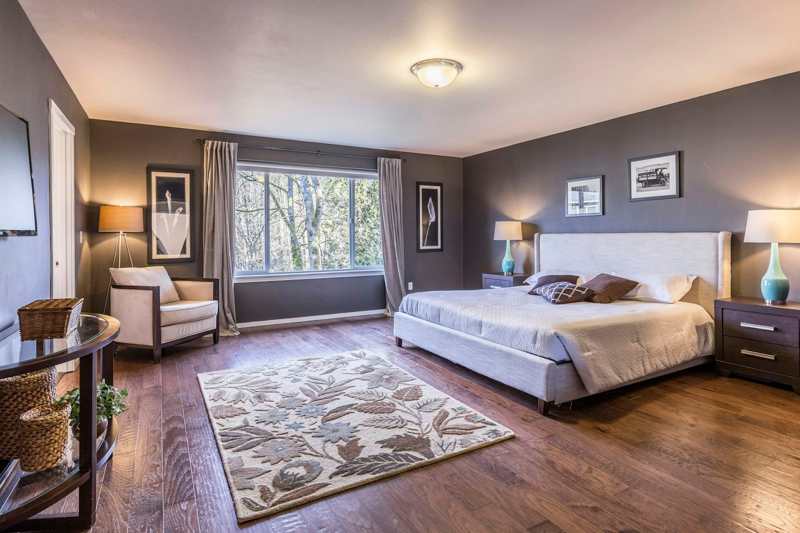 Bedroom with a floral area rug on a wooden floor (photo: Francesca Tosolini / Unsplash)