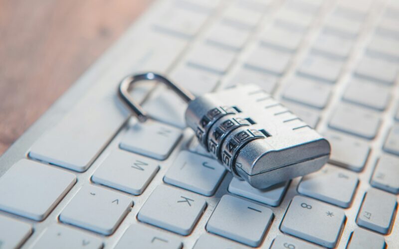 A combination padlock resting on a white laptop keyboard (photo: Sasun Bughdaryan / Unsplash)
