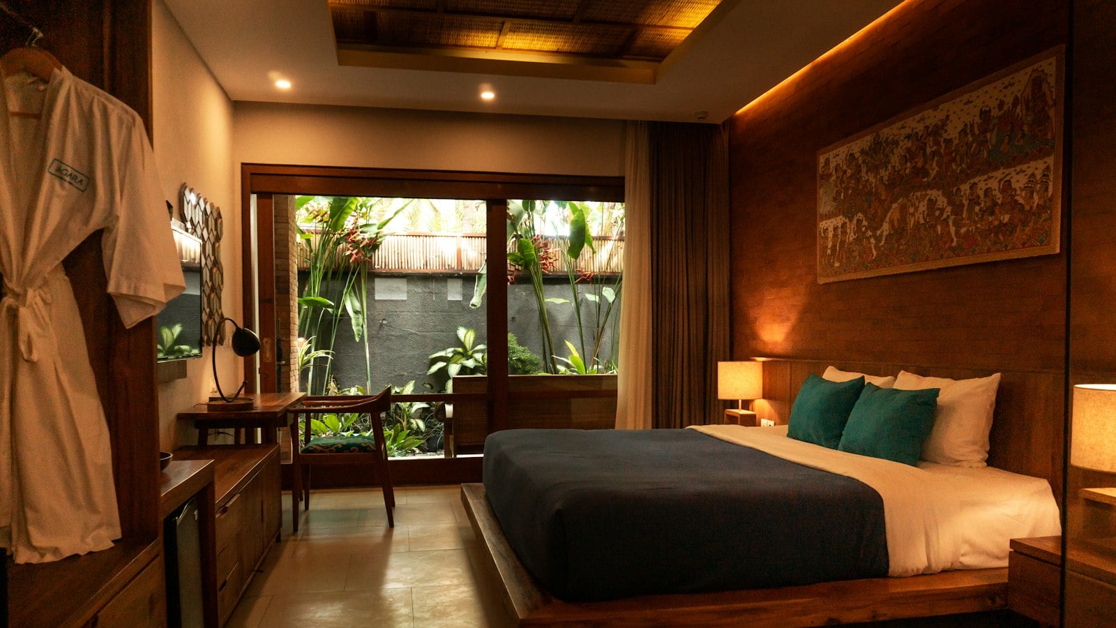 A warmly lit boutique hotel room with a wooden bed and garden view (photo: visualsofdana / Unsplash)