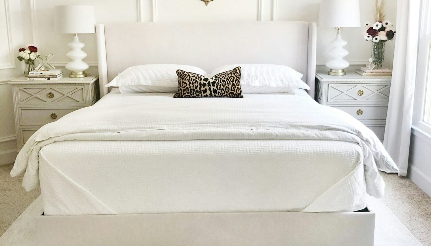 Bright bedroom with a made white bed, upholstered headboard and matching nightstands (photo: Trend / Unsplash)