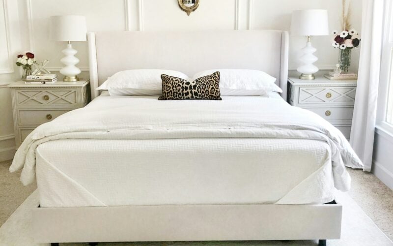 Bright bedroom with a made white bed, upholstered headboard and matching nightstands (photo: Trend / Unsplash)