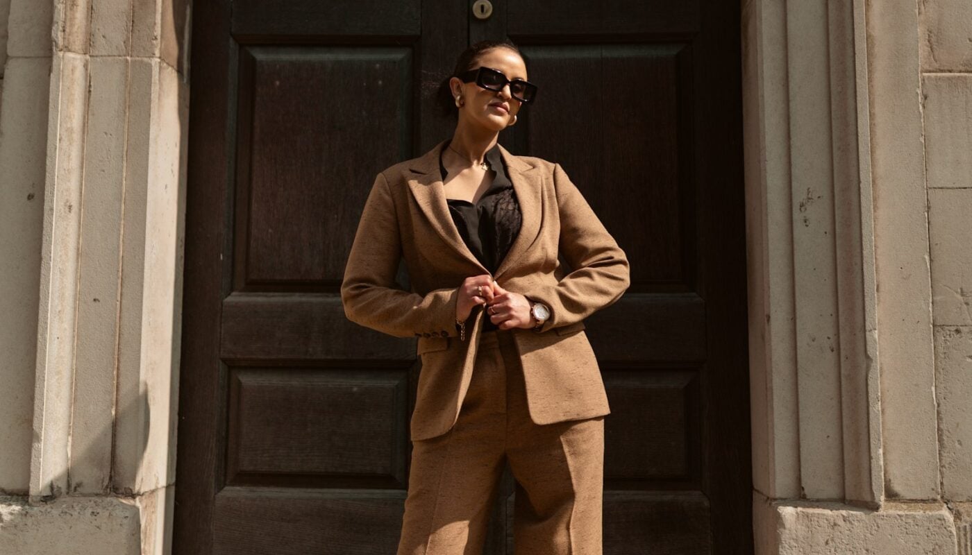 Woman in a brown suit standing in a doorway (photo: Alekon pictures / Unsplash)