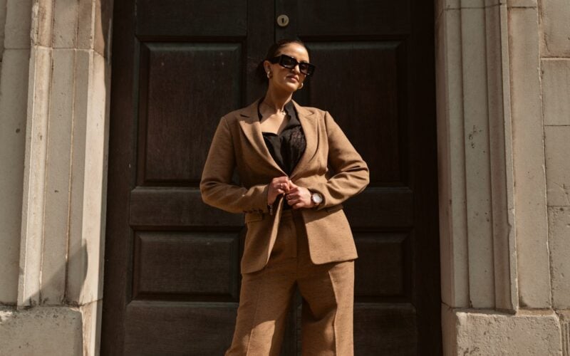 Woman in a brown suit standing in a doorway (photo: Alekon pictures / Unsplash)