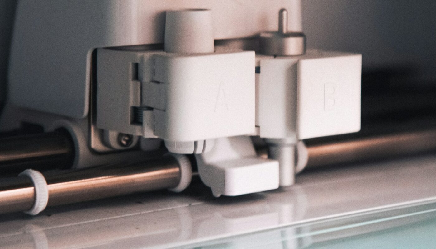 Close view of the tool carriage on a white Cricut cutting machine, with its two tool clamps (photo: Caroline Eymond Laritaz / Unsplash)