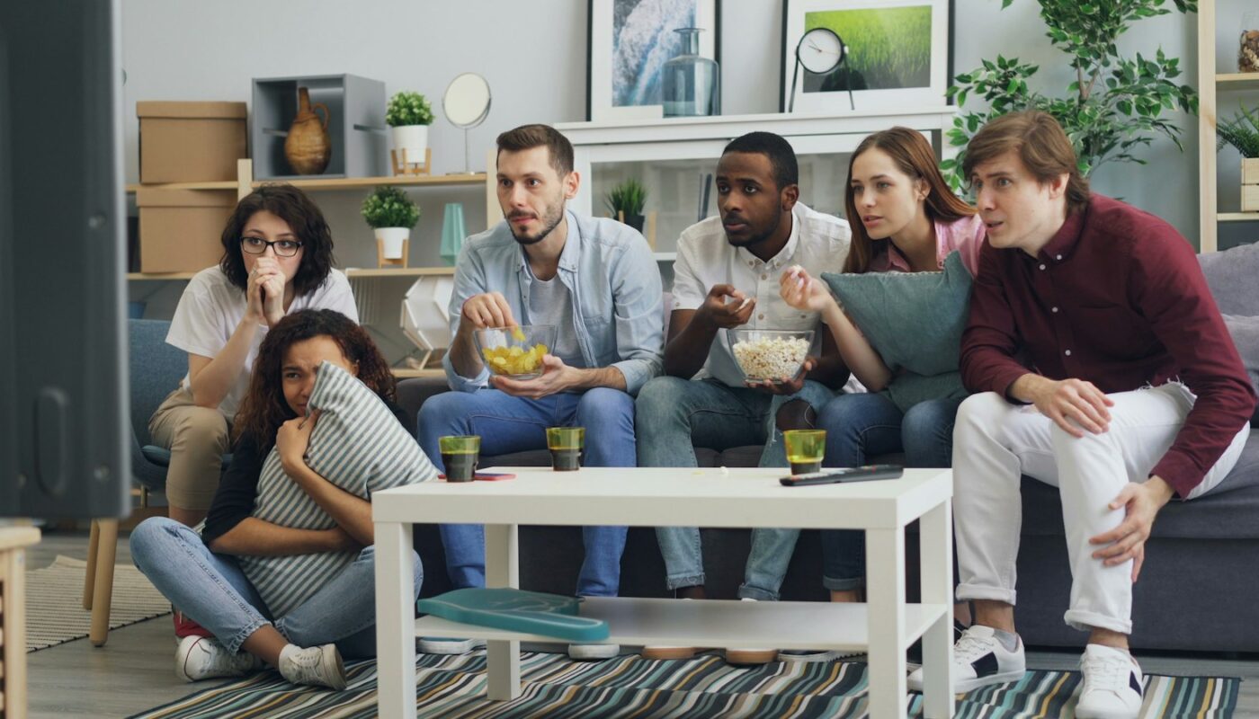 Friends on a sofa watching a show together (photo: Vitaly Gariev / Unsplash)