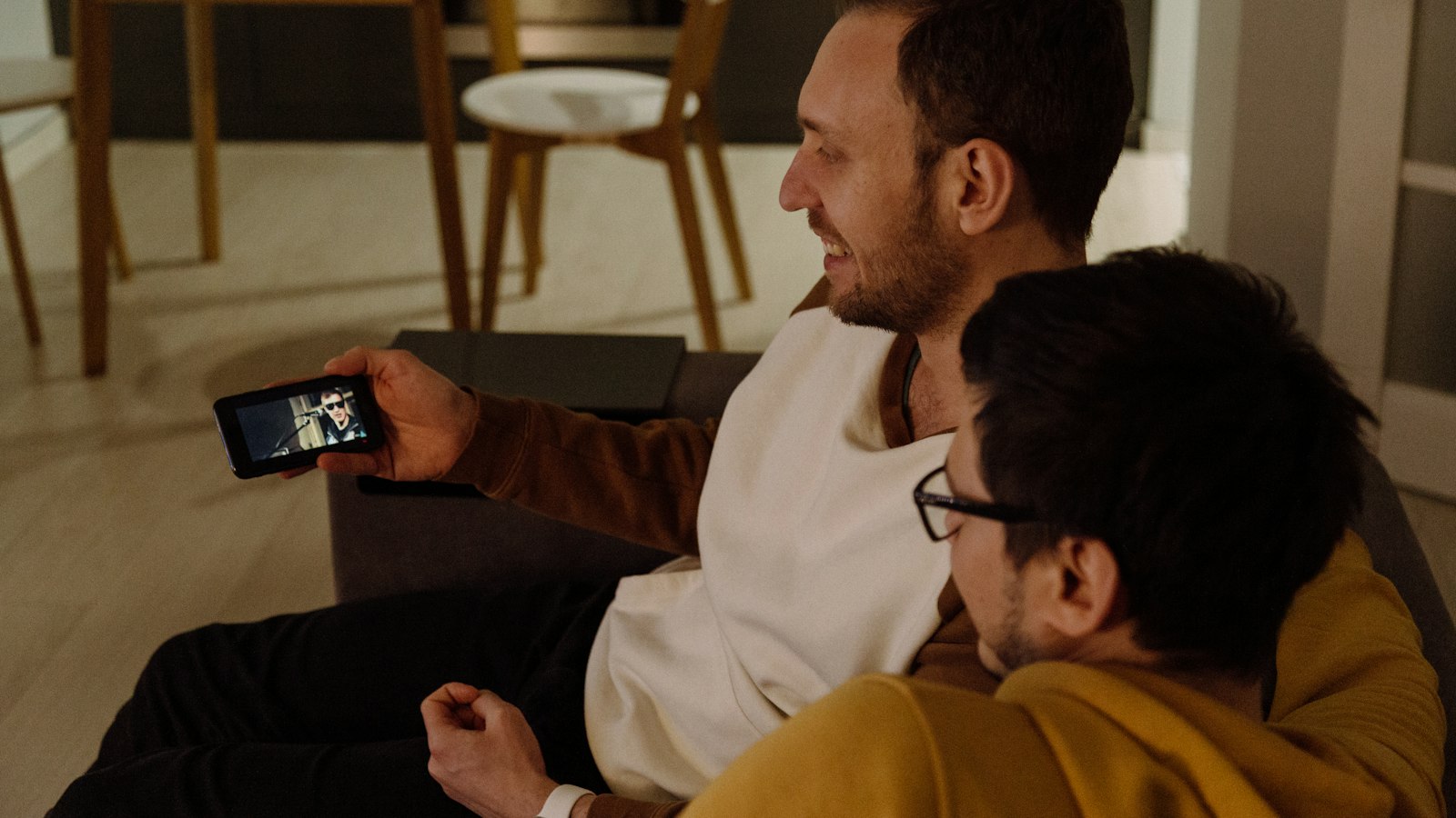 Two friends watching something on a phone (photo: Alex Suprun / Unsplash)
