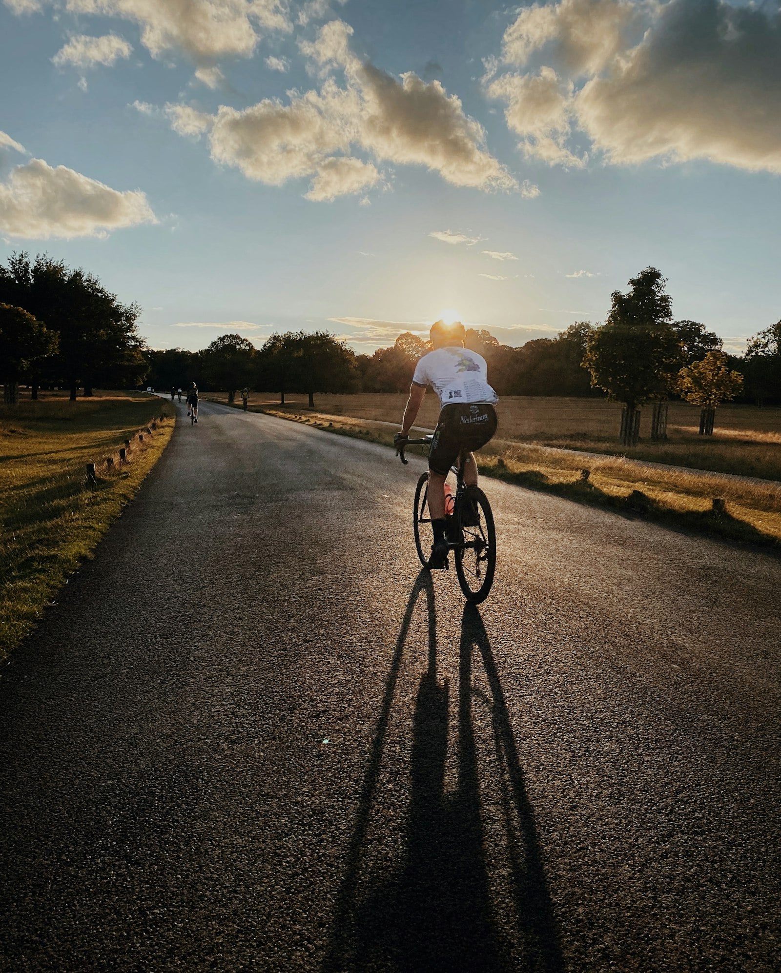 Cyclist riding along a road at sunset (photo: Hannah Carr / Unsplash)