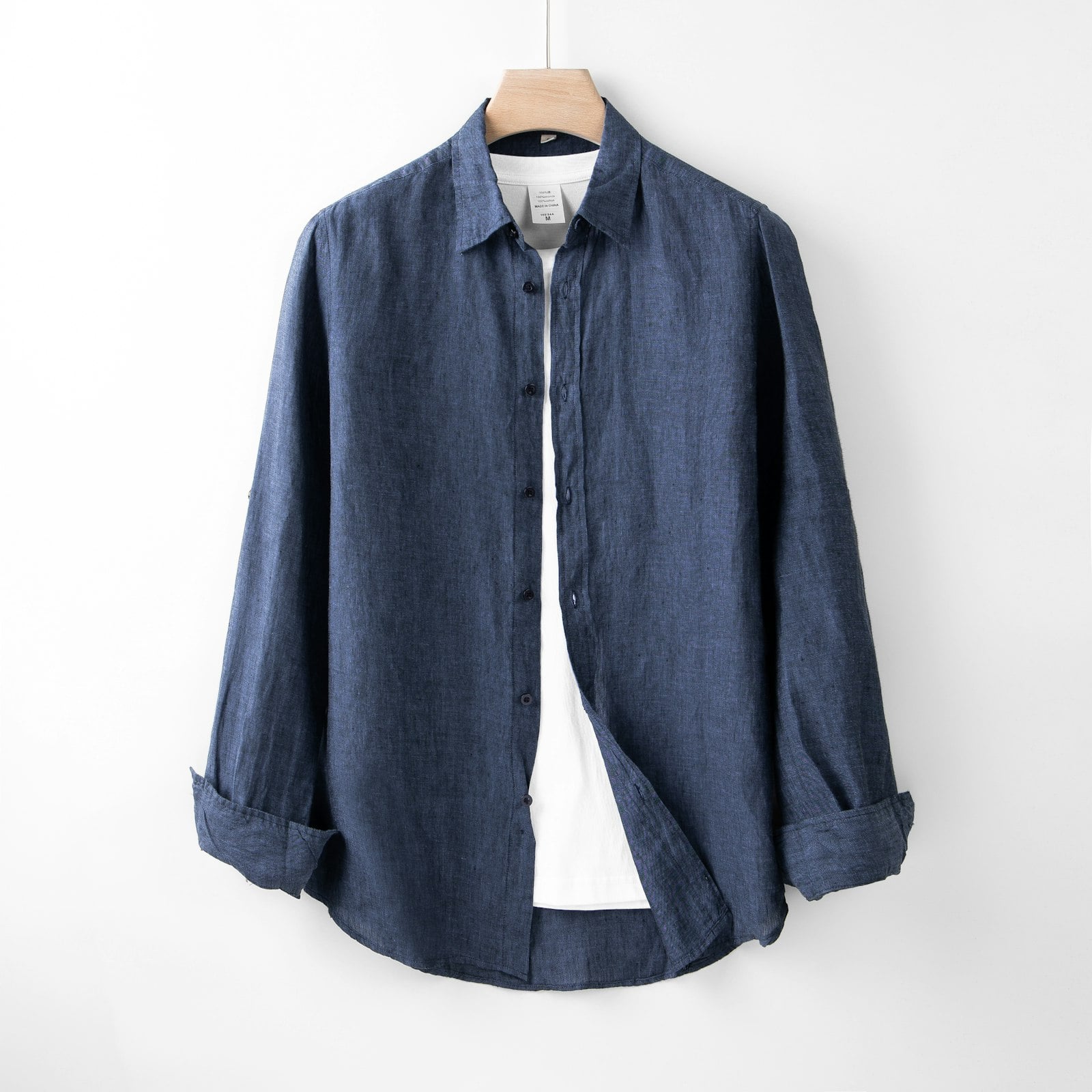 Blue button-down shirt on a hanger (photo: Robert Richman / Unsplash)