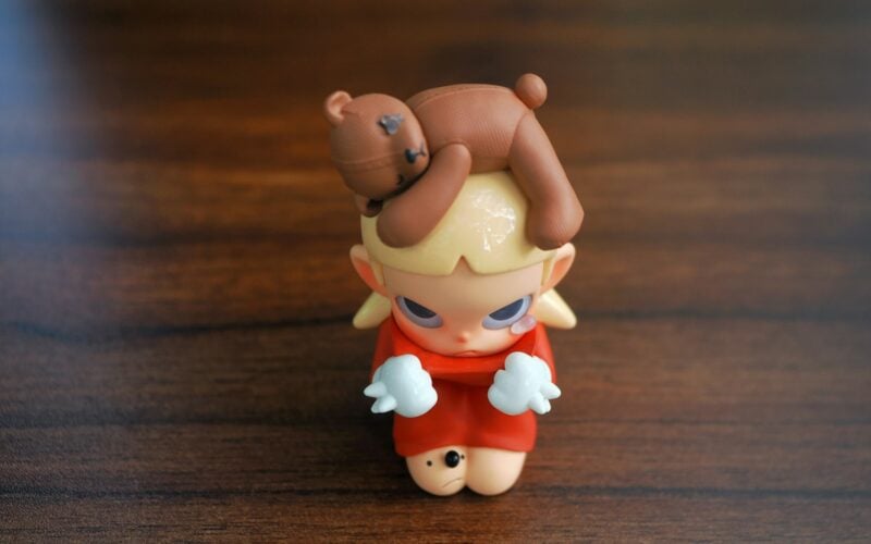 Small designer collectible figure on a wooden table (photo: Trương Tuyết Ly / Unsplash)