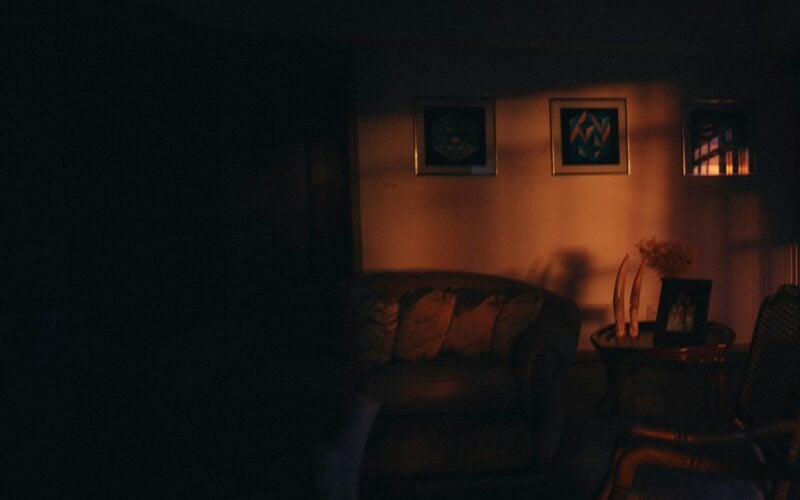 Dimly lit living room at night with framed art on the wall (photo: Helena Lopes / Unsplash)