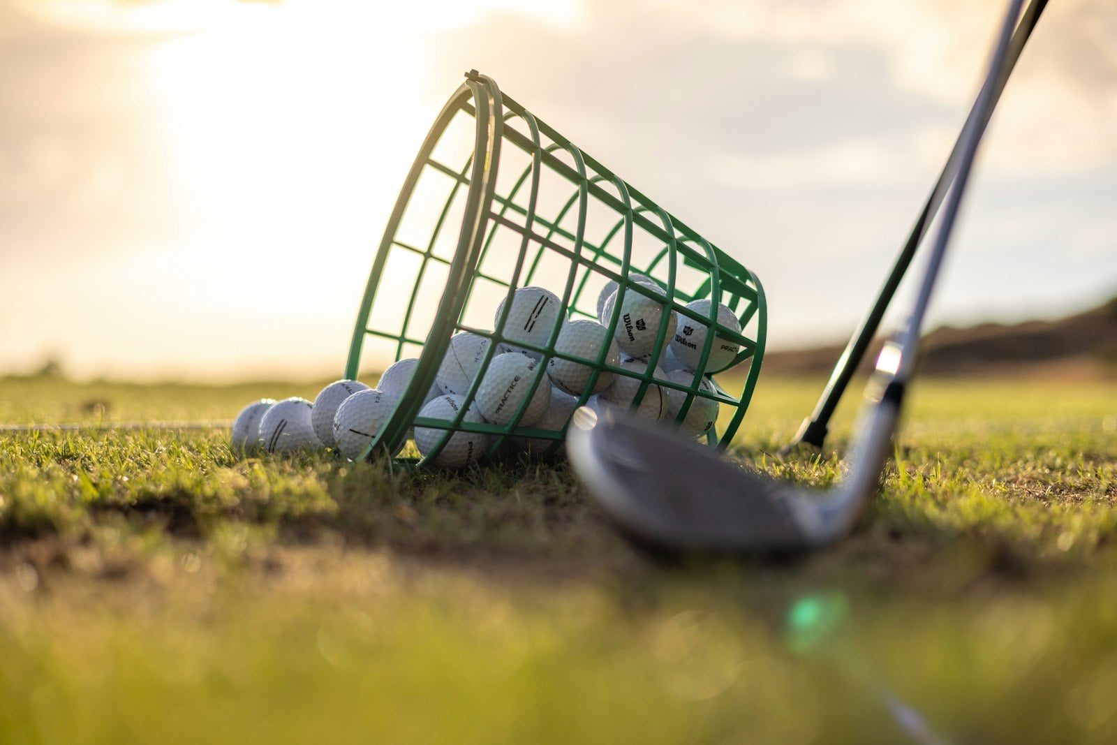 Basket of golf balls tipped over on a driving range (photo: Daniel Stenholm / Unsplash)
