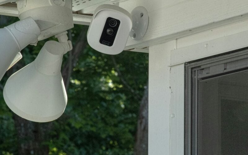 Security camera and floodlight mounted on a house porch (photo: Mary Oakey / Unsplash)