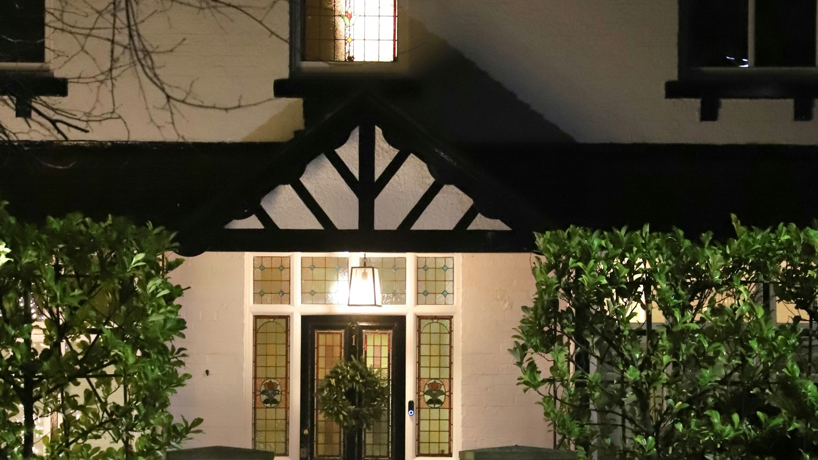Front of a house lit up at night (photo: Bruce Barrow / Unsplash)