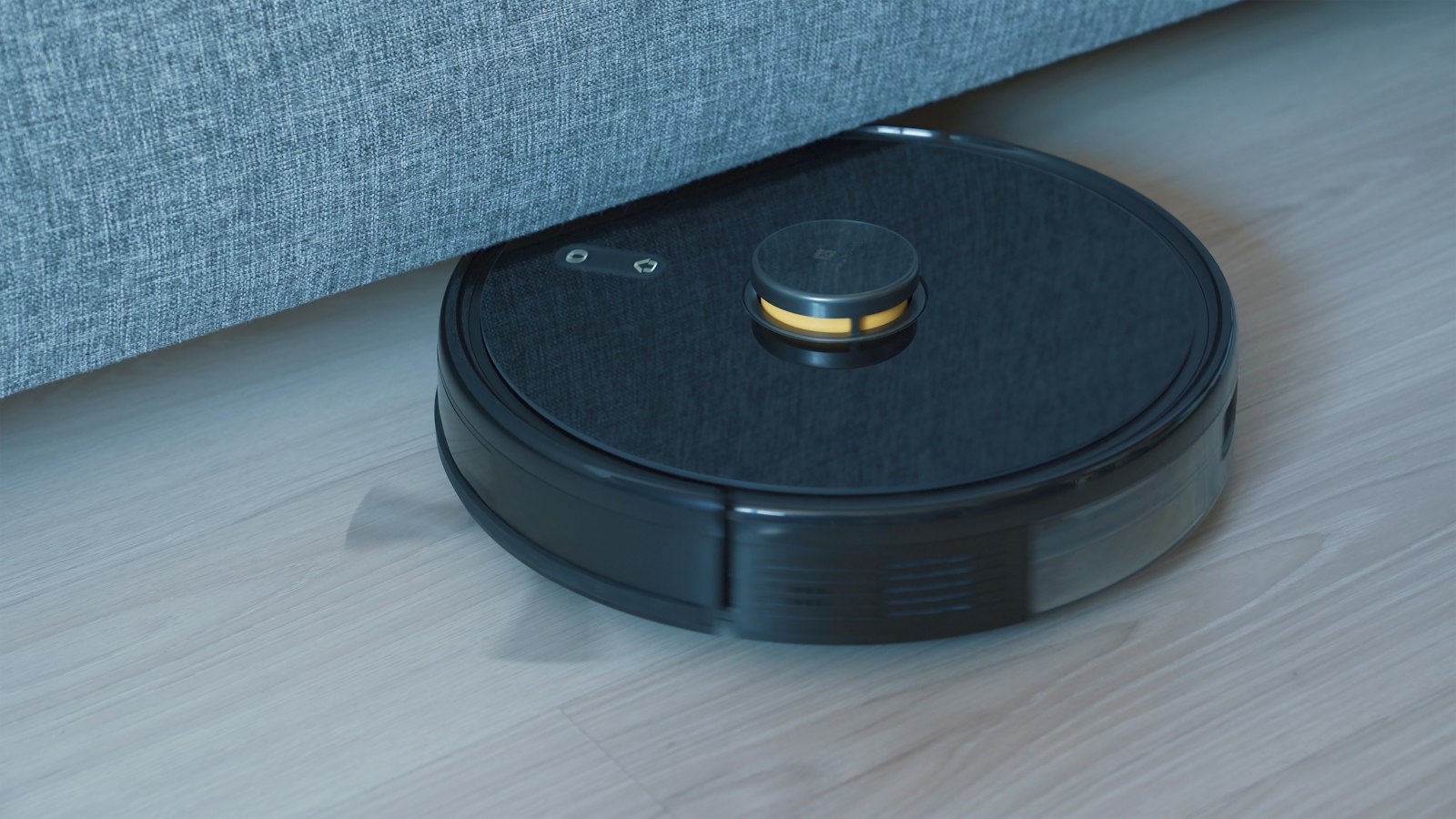 Robot vacuum cleaning under a sofa (photo: Onur Binay / Unsplash)