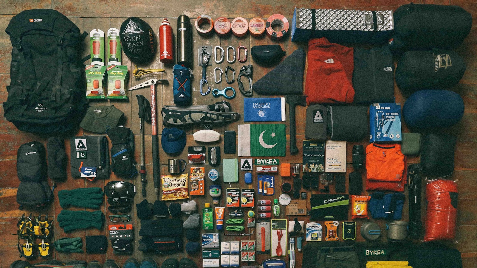 A full set of hiking and camping kit laid out flat, from pack and boots to stove and small tools (photo: Muhammad Masood / Unsplash)