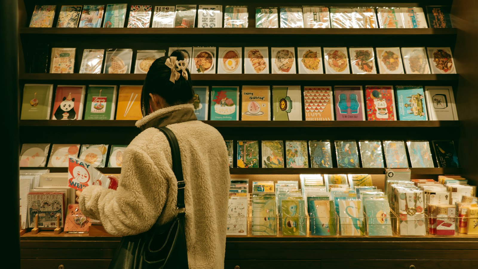 A shopper browsing rows of greeting cards (photo: Raymond Yeung / Unsplash)