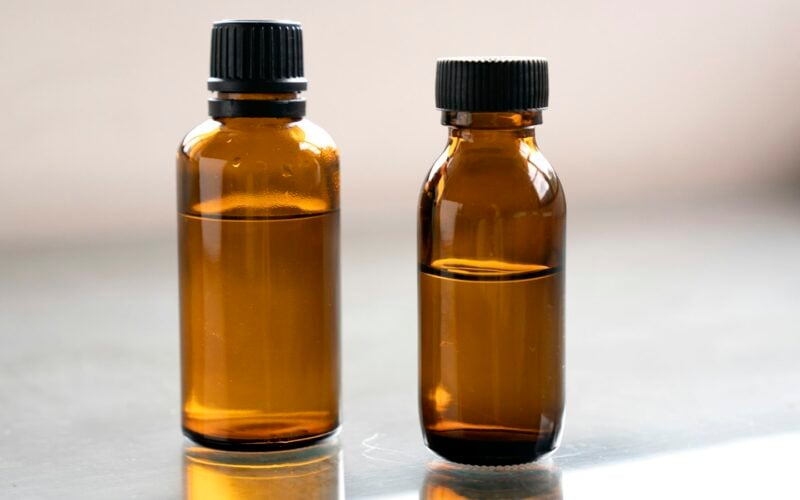 Two small amber glass bottles on a grey surface (photo: Denise Chan / Unsplash)