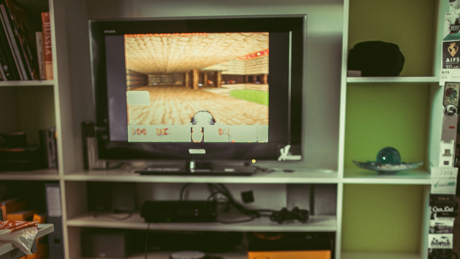 A child sitting on the floor in front of a shelf of games and consoles (photo: Arphy / Unsplash)