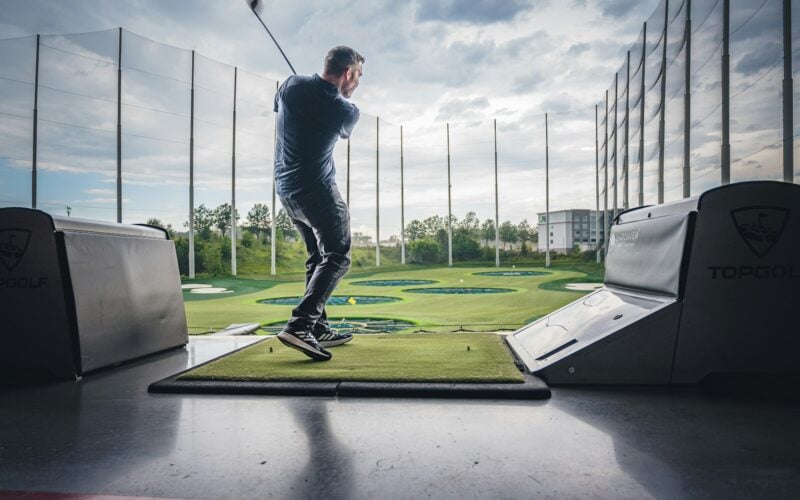 Golfer finishing a tee shot on a sunny course (photo: Matt Benson / Unsplash)
