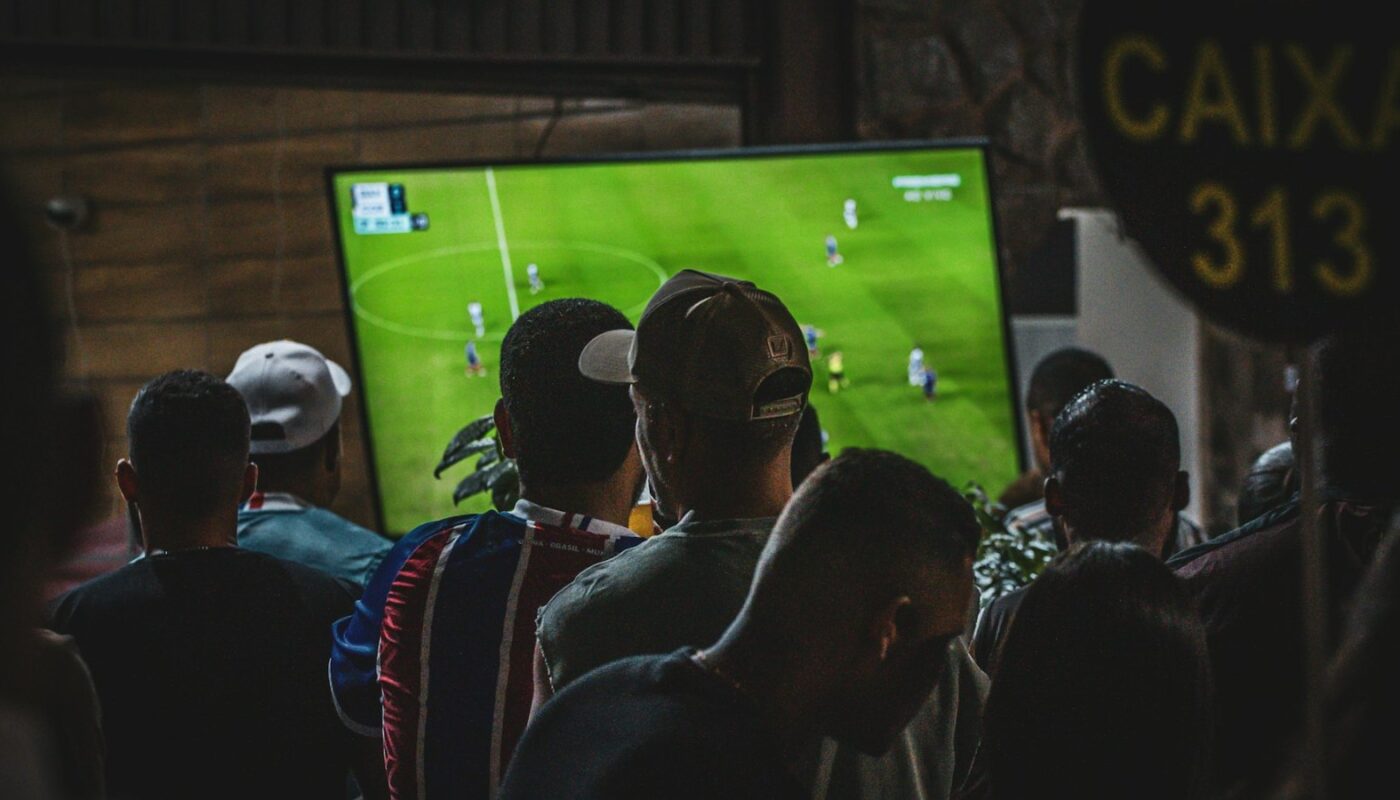 Group of people watching a football match on television (photo: Luciano Oliveira / Unsplash)