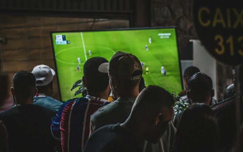 Group of people watching a football match on television (photo: Luciano Oliveira / Unsplash)