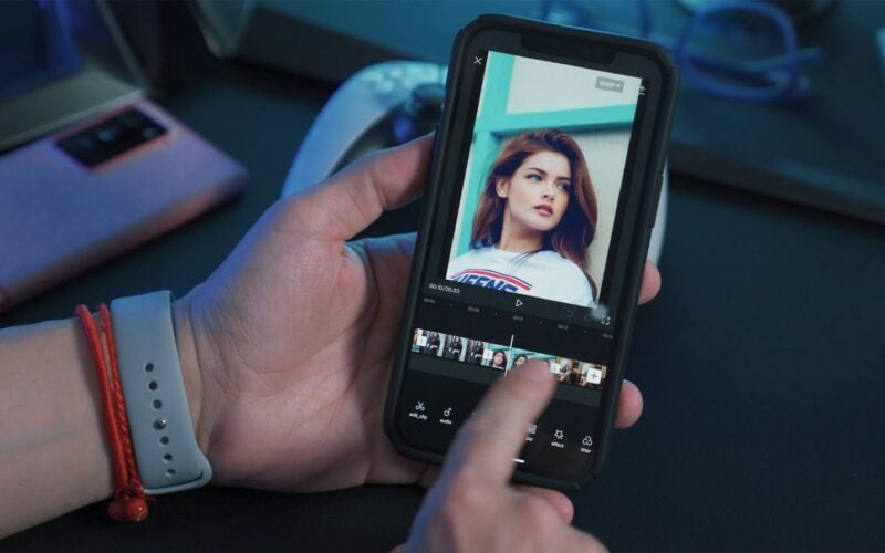 Hand holding a smartphone playing a video (photo: Onur Binay / Unsplash)