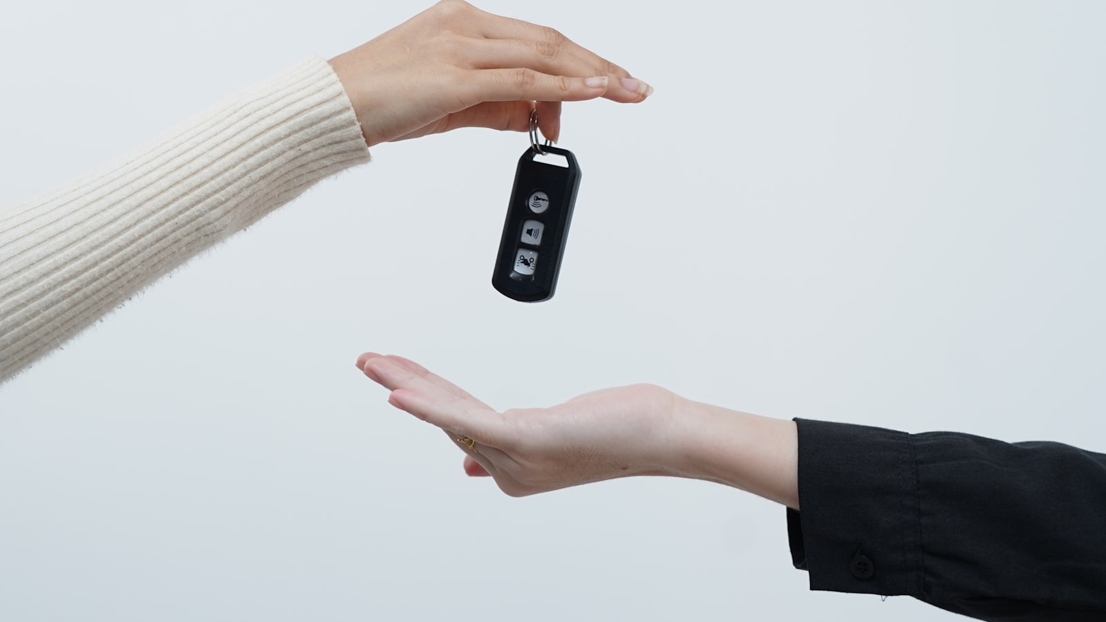 Two pairs of hands exchanging a set of car keys (photo: yahdi yasya / Unsplash)