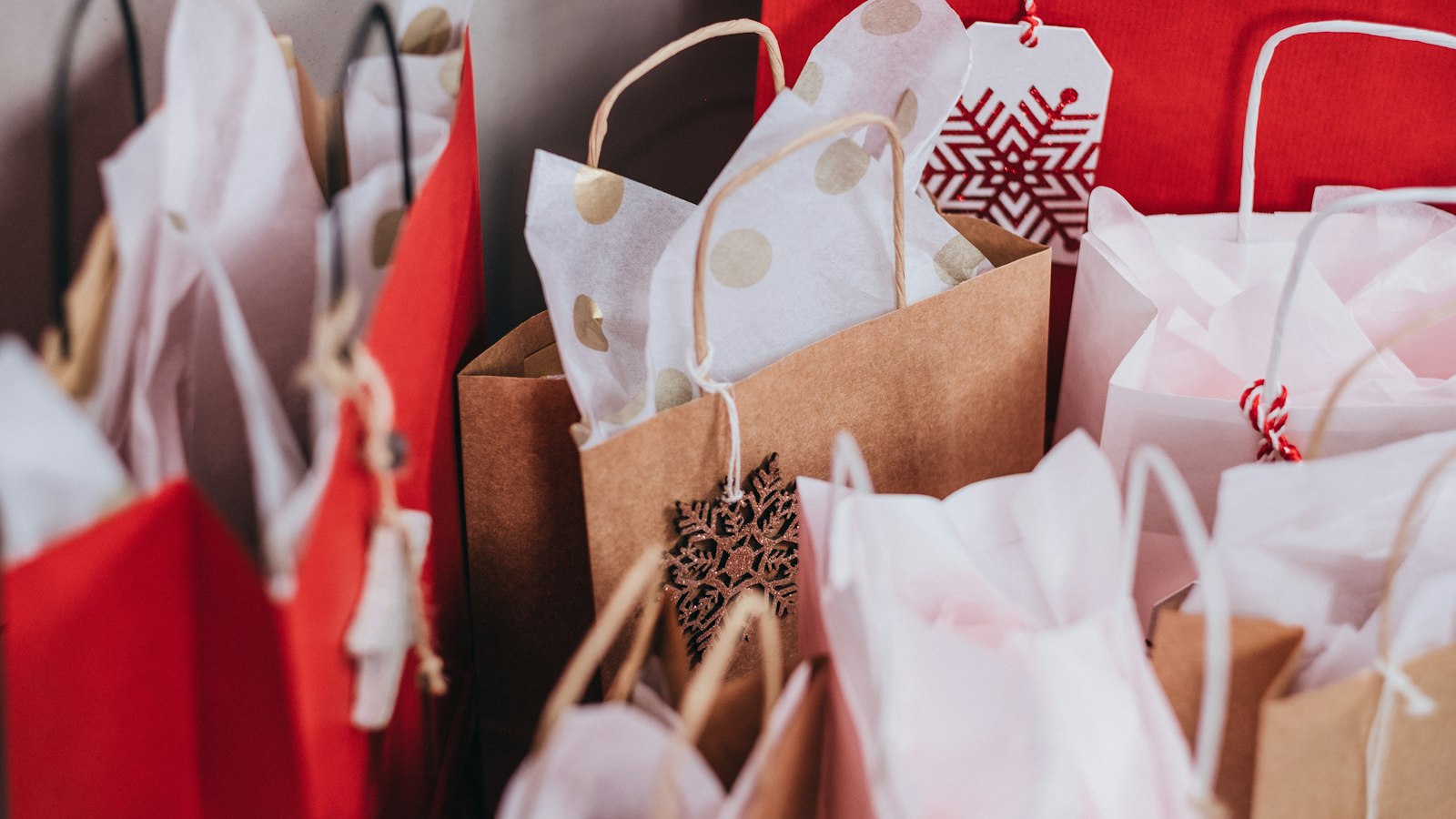 Gift bags in red and white tissue paper (photo: freestocks / Unsplash)