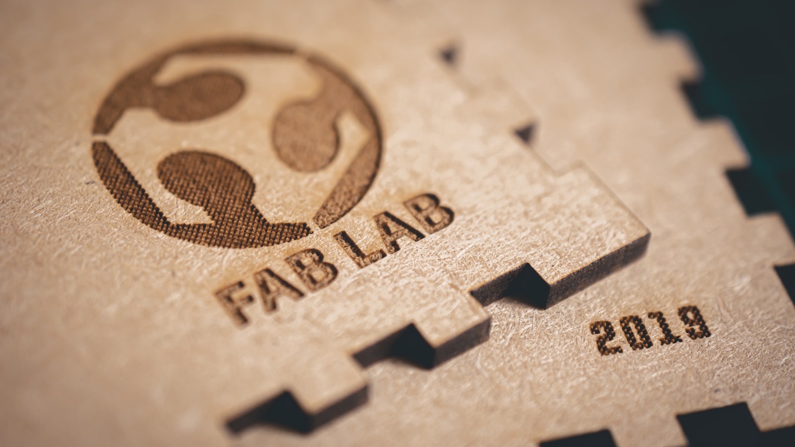 A plywood panel laser-engraved with a logo and lettering, with cut edges (photo: Alexandre Debieve / Unsplash)