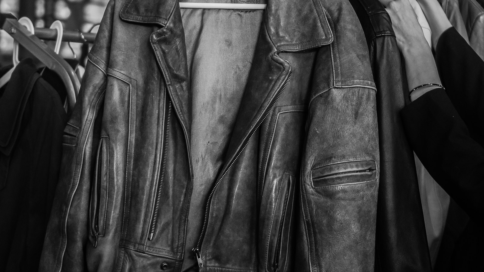 A row of leather jackets hanging close together on a rail (photo: Alexander Grigoryev / Unsplash)