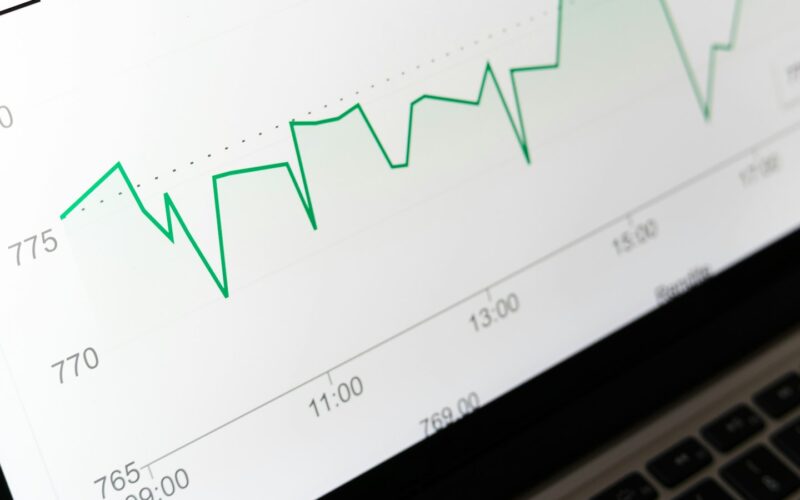 A close view of a green line chart rising and falling across a laptop screen (photo: Markus Winkler / Unsplash)