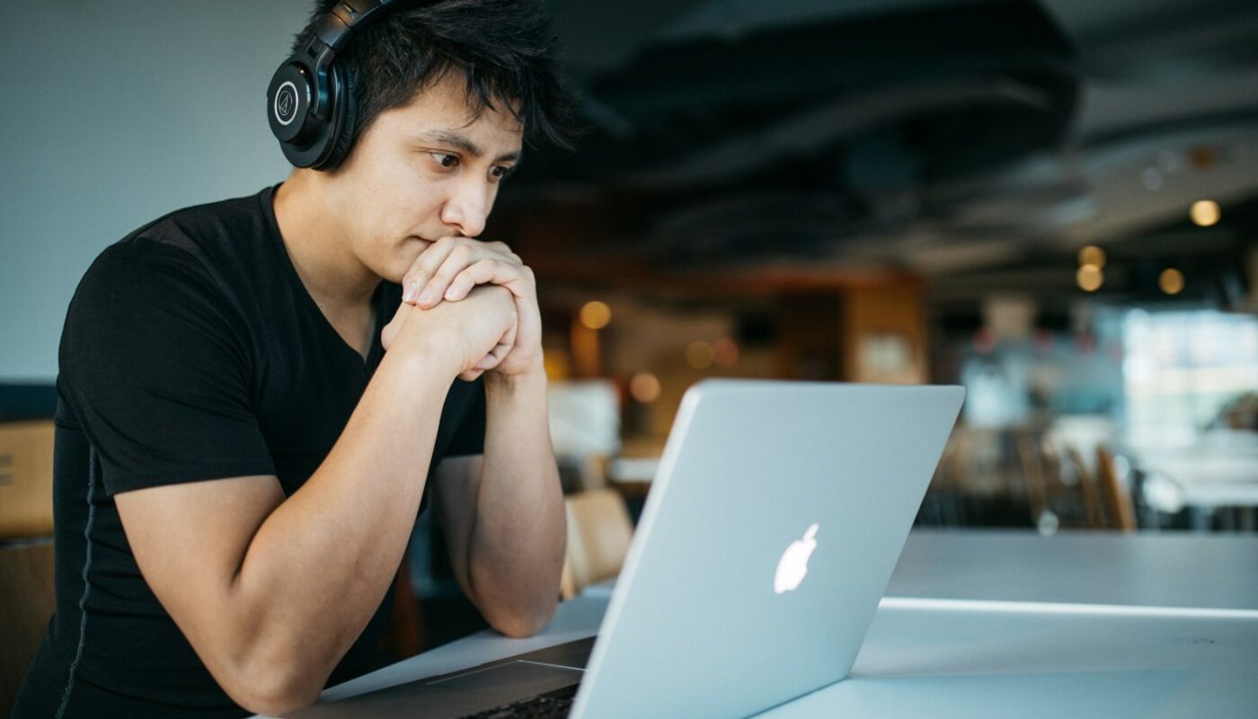 Man wearing headphones studying at a MacBook (photo: Wes Hicks / Unsplash)