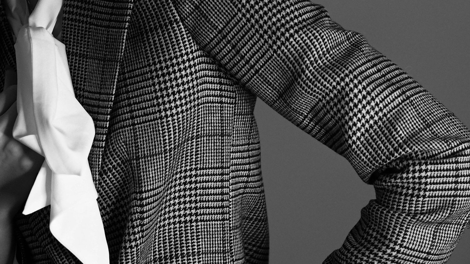 A close-up of a checked wool blazer over a white shirt (photo: Laura Chouette / Unsplash)