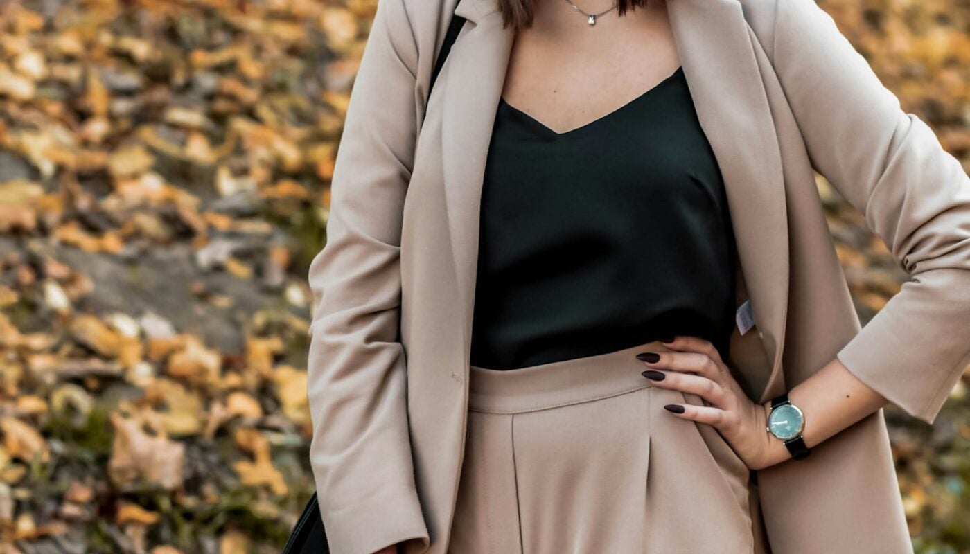 Woman in a neutral blazer and trousers outdoors (photo: Roman Holoschchuk / Unsplash)