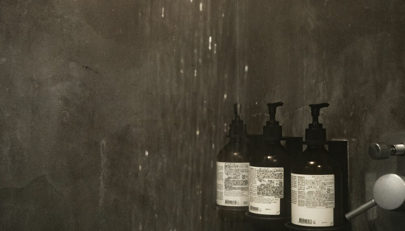 Bottles of shampoo and conditioner on a shower shelf (photo: Susan Q Yin / Unsplash)