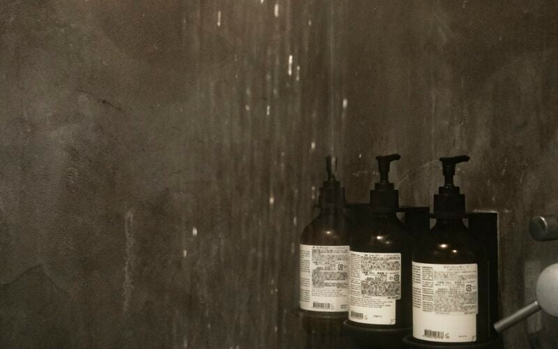 Bottles of shampoo and conditioner on a shower shelf (photo: Susan Q Yin / Unsplash)
