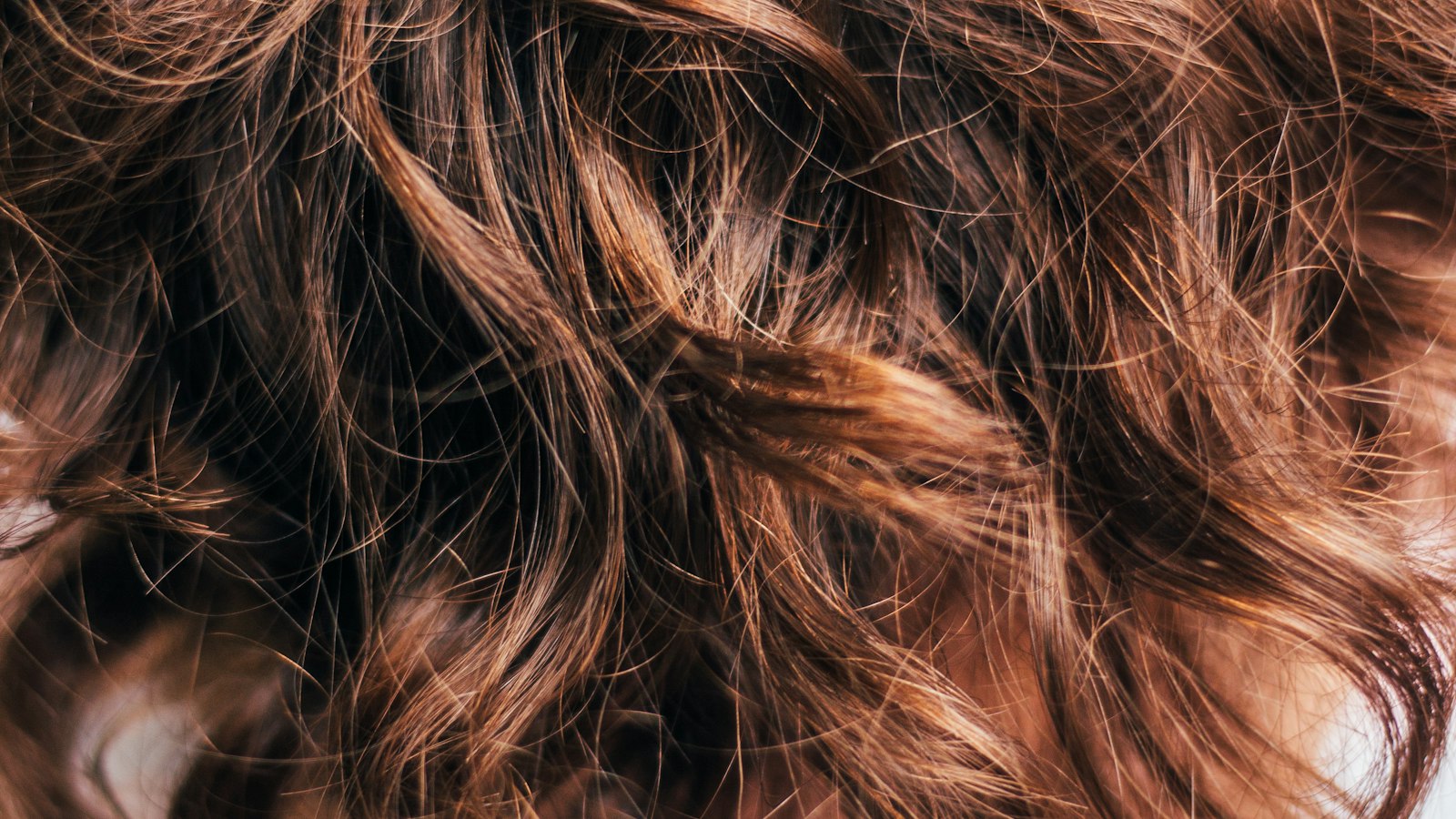Close-up of wavy brown hair texture (photo: Paul Siewert / Unsplash)