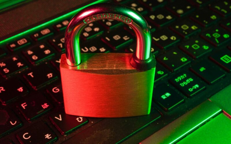 Red padlock resting on a black computer keyboard (photo: FlyD / Unsplash)