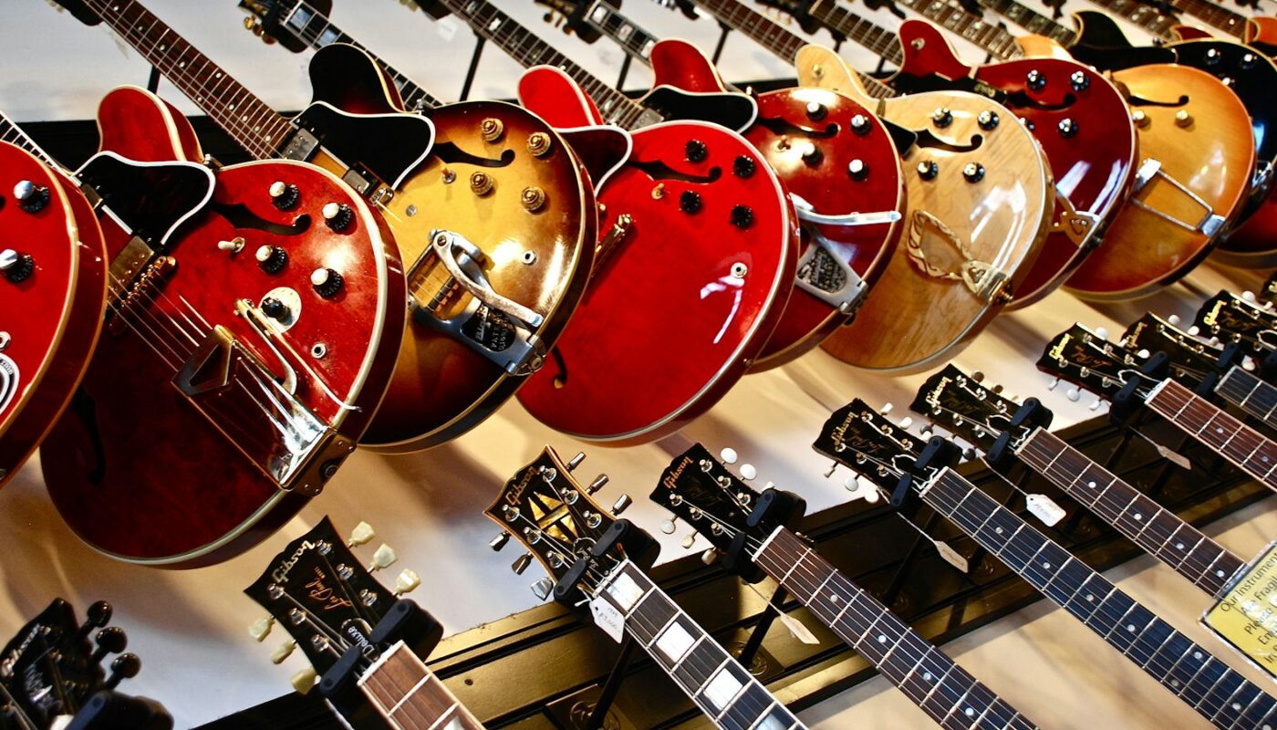 Rows of electric guitars hanging on a shop wall (photo: Susan Mohr / Unsplash)