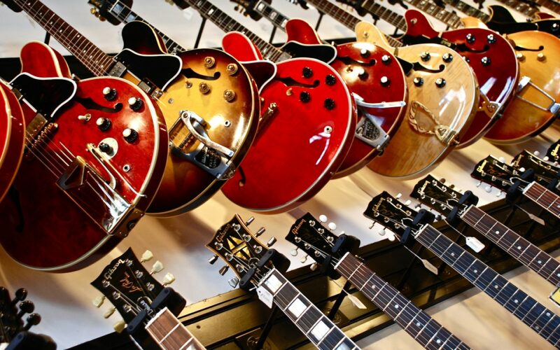 Rows of electric guitars hanging on a shop wall (photo: Susan Mohr / Unsplash)