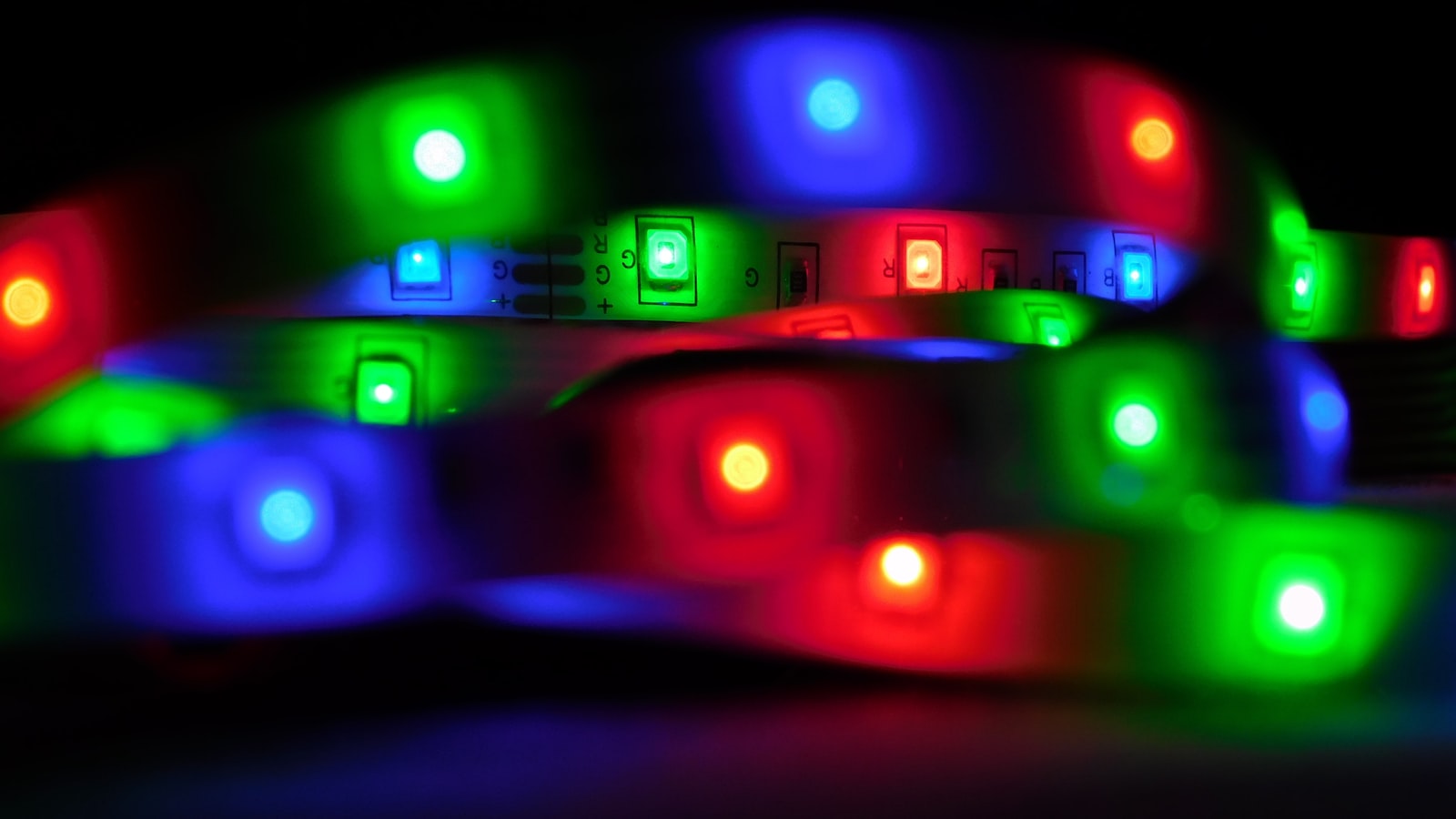 An RGB LED strip lit in the dark, showing the individual diodes along the ribbon (photo: Zishan khan / Unsplash)