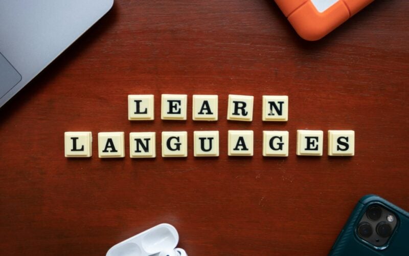 Scrabble tiles on a wooden table spelling learn languages (photo: Ling App / Unsplash)
