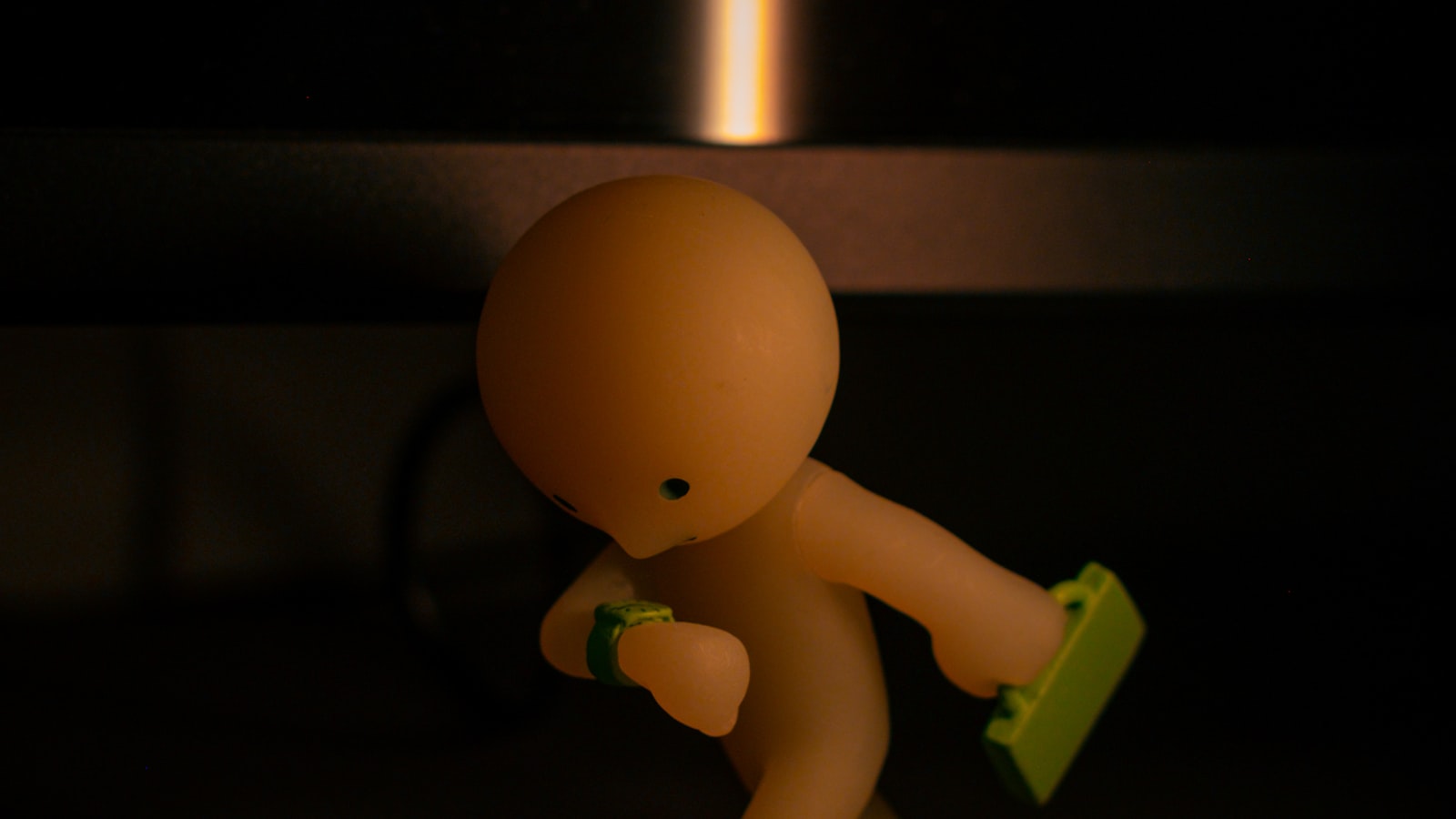 A single small collectible figure holding a green object (photo: Tamara Badran / Unsplash)