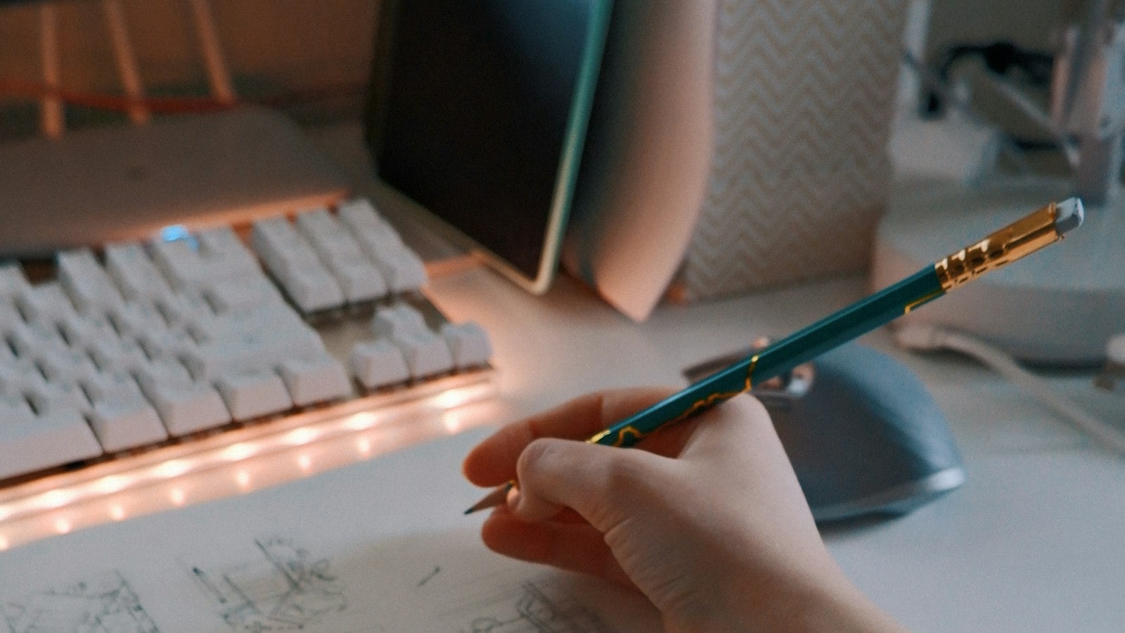 A hand drawing rough storyboard frames in pencil across an open sketchbook