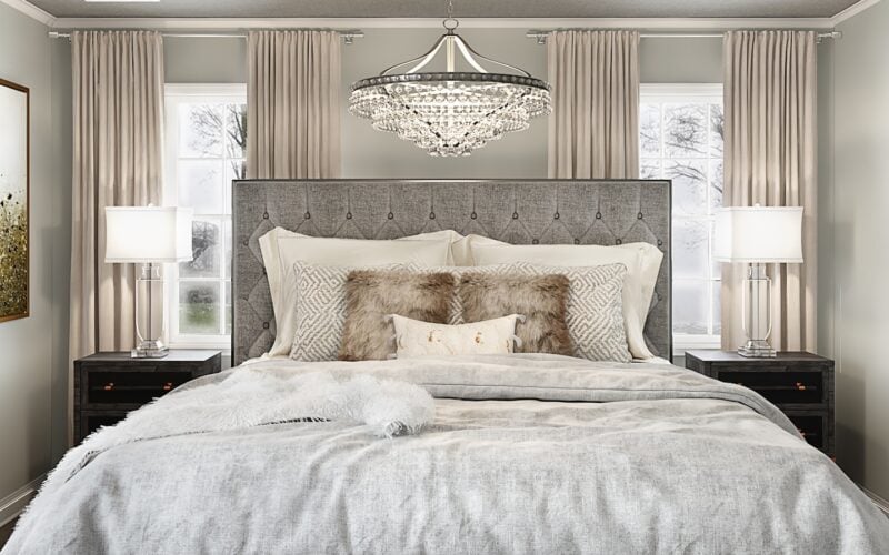 A large made bed in a warmly styled bedroom with bedside lamps and layered bedding (photo: Spacejoy / Unsplash)