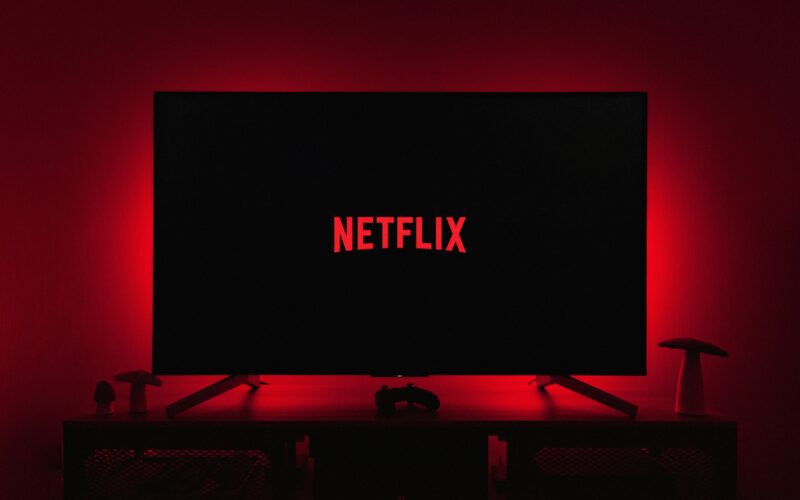 Netflix logo on a television screen with red ambient lighting behind it