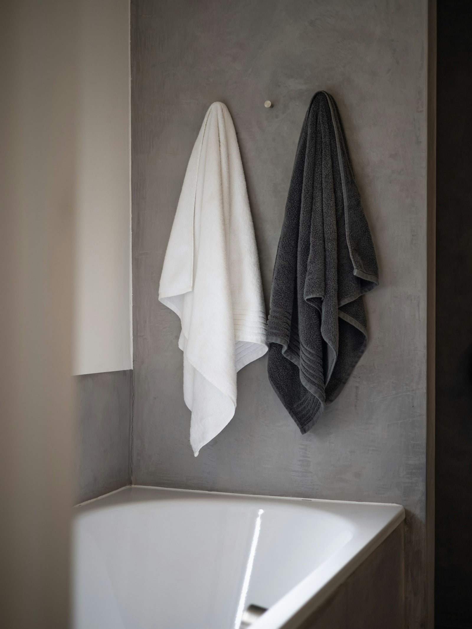White and grey towels hanging in a bathroom (photo: the blowup / Unsplash)