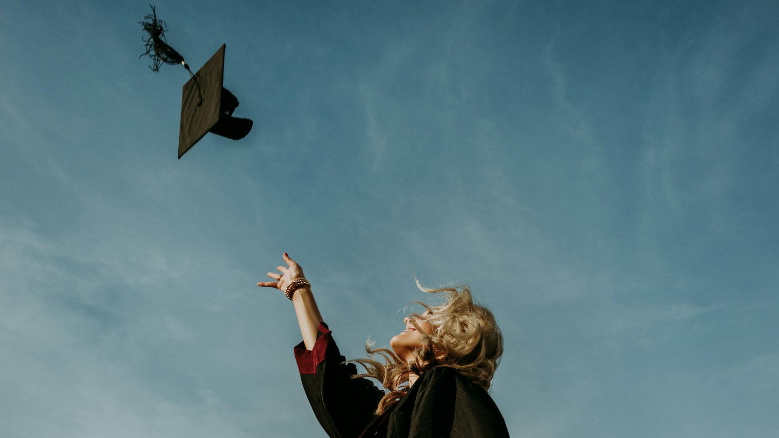 Graduate throwing a cap into the sky (photo: Caleb Holden / Unsplash)