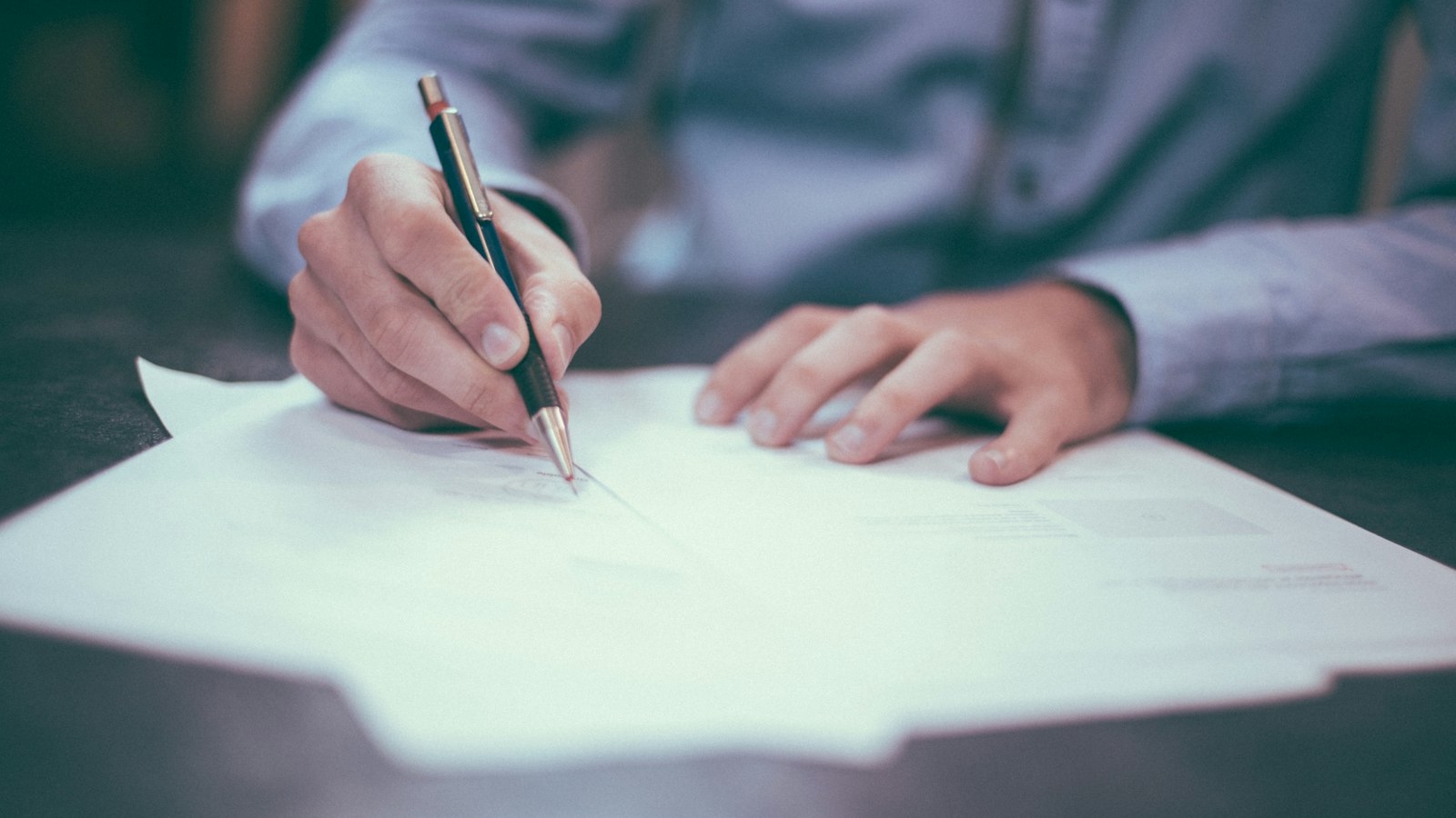 Signing a document with a pen (photo: Scott Graham / Unsplash)